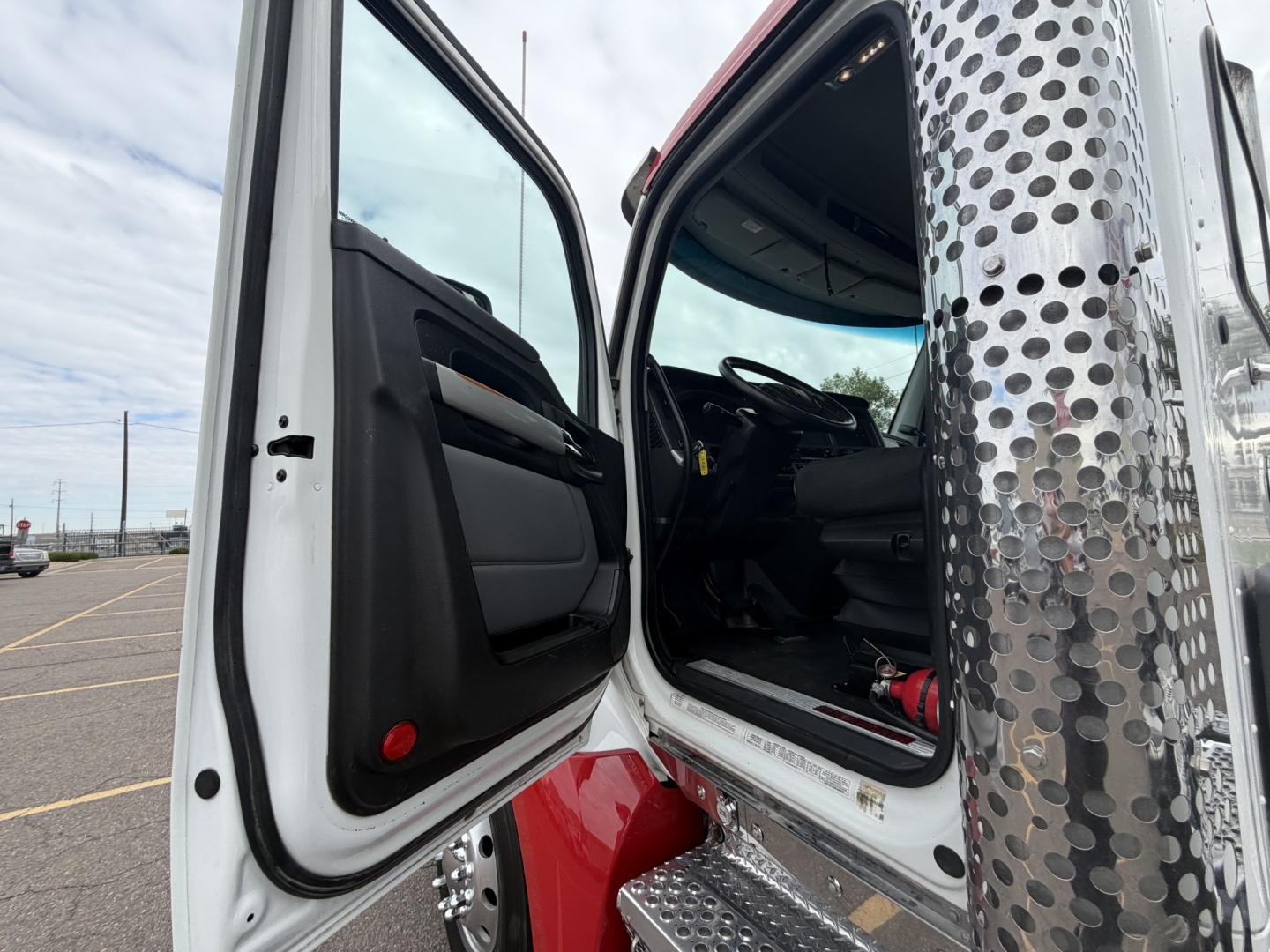 Kenworth T880 cab interior and open door showing steering wheel and dashboard from outside.