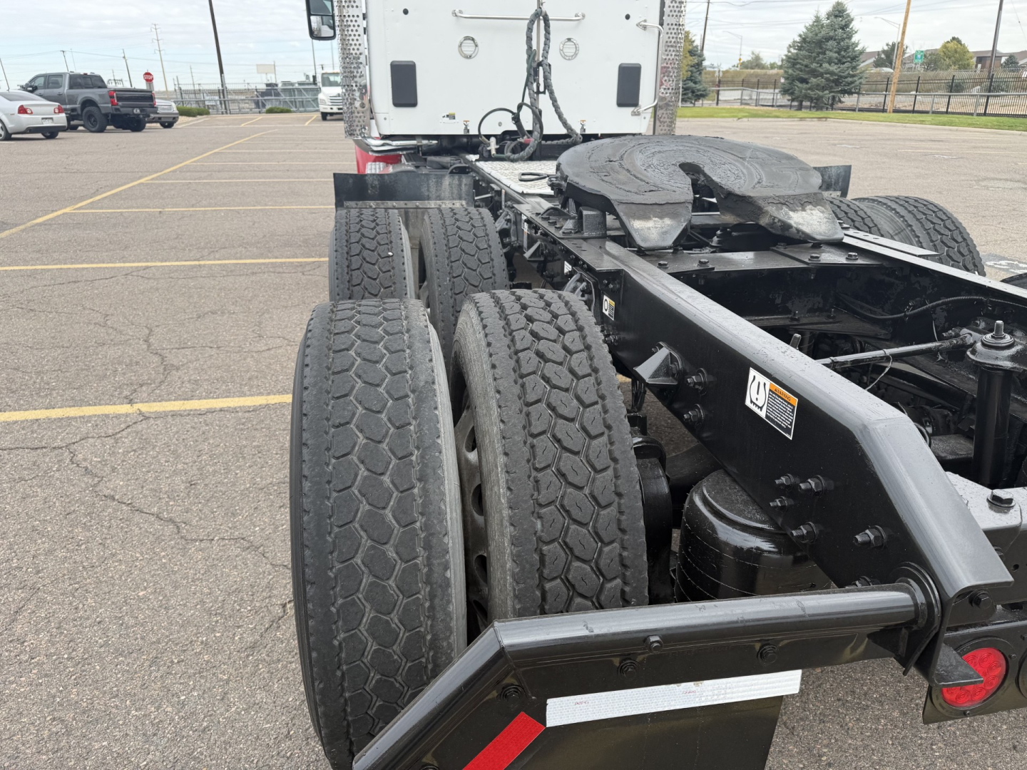 Kenworth T880 chassis rear view showing dual rear axles, tandem axle tires, and fifth wheel area.