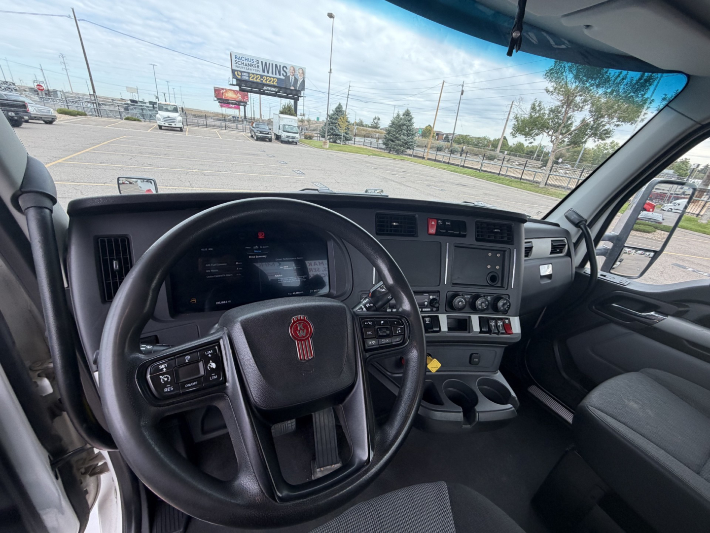 Cab interior of a 2023 Kenworth T880 with steering wheel, dashboard, and controls visible.