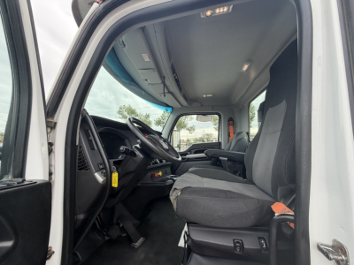 Kenworth T880 cab interior showing steering wheel, driver seat, dashboard, and front door area; overhead light and windows visible.