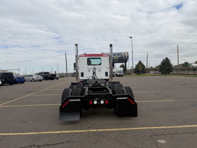 Kenworth T880 rear view showing fifth wheel area and dual rear axles in a parking lot.