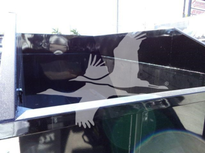 Dump trailer side panel of a 2020 Peterbilt 337 rolloff truck showing reflective black surface and metal trim.