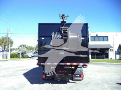 Peterbilt 337 roll-off truck rear view showing cargo container and hydraulic hooklift arms.