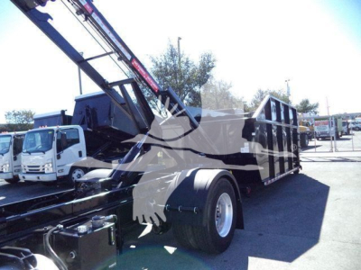Peterbilt 337 roll-off truck with crane and dump bed, side view showing rear wheel and hydraulic components.