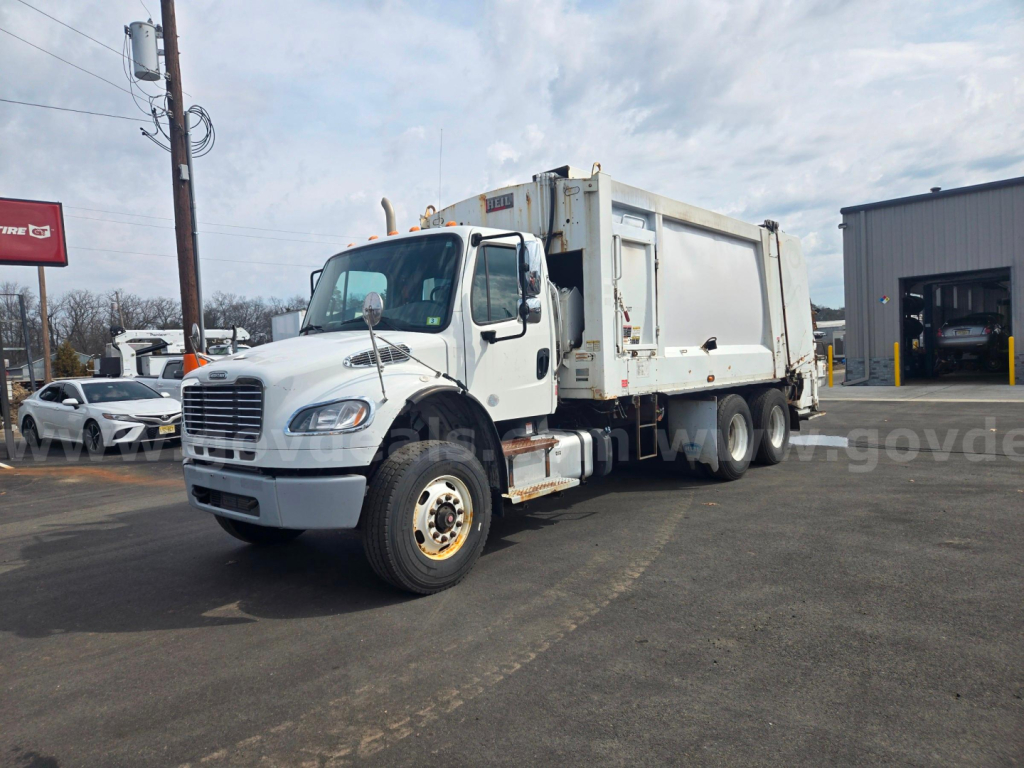 Truck diagnostics not visible; Freightliner M2 garbage truck with front cab and rear refuse body, white, stock number 29174-63, used condition.