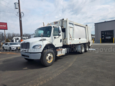 Truck diagnostics not visible; Freightliner M2 garbage truck with front cab and rear refuse body, white, stock number 29174-63, used condition.