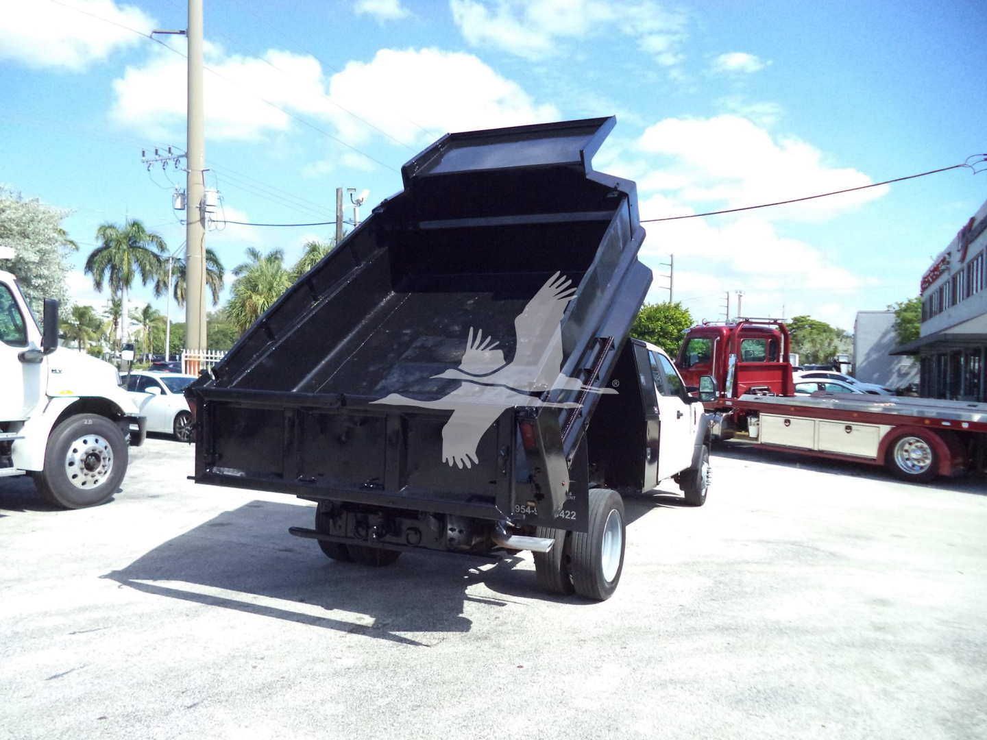 Dump truck bed raised on a 2017 Ford F450 XL dump truck showing the open dump bed and rear tires.