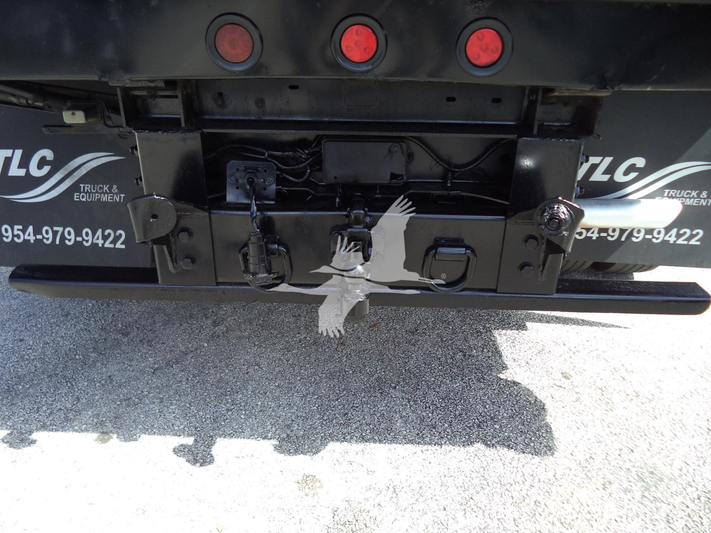 Ford F-450 chassis back showing hitch and connectors with TLC truck equipment logos.