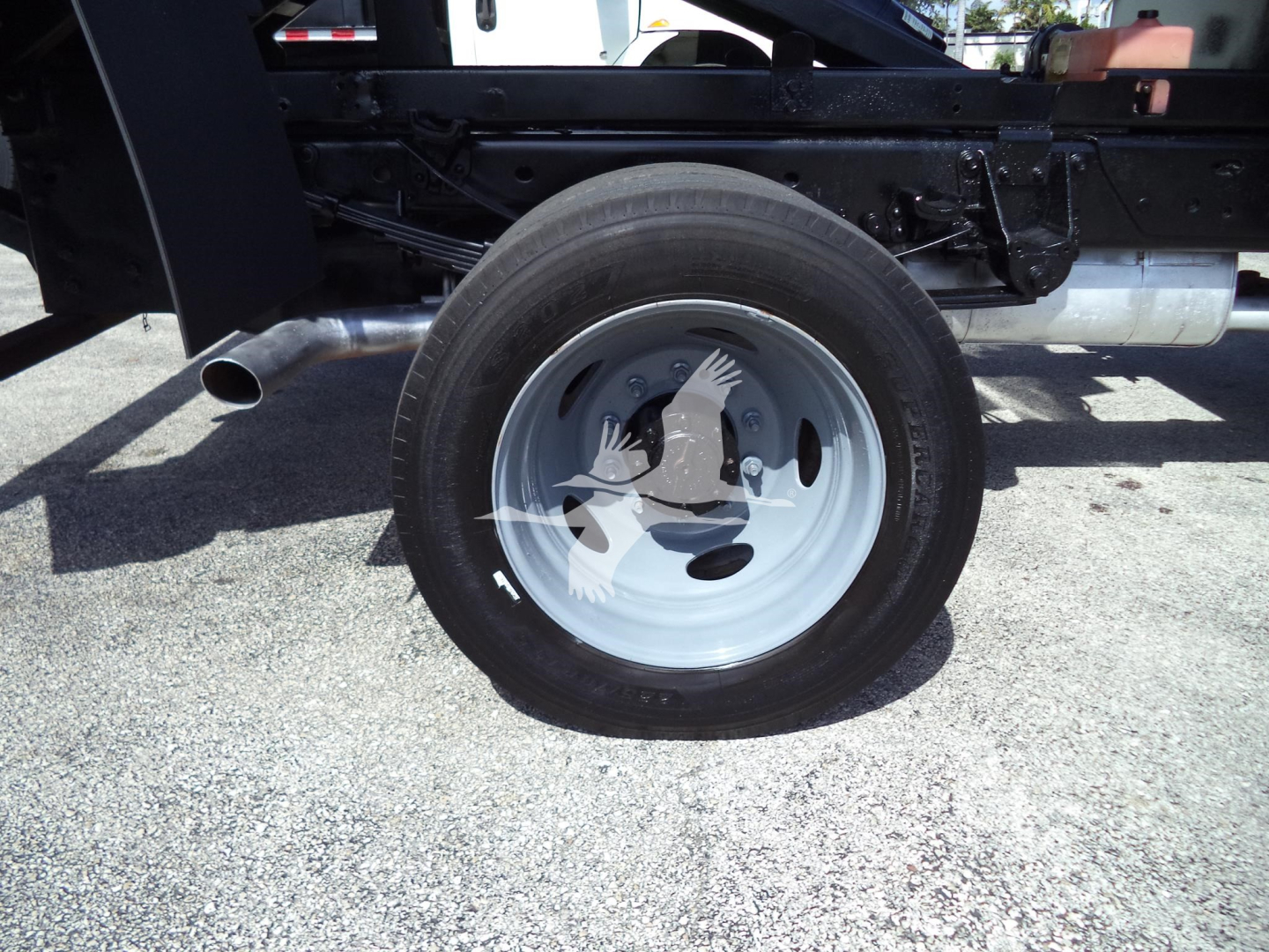 Ford F-450 chassis showing rear wheel and undercarriage with black frame and silver wheel rim.
