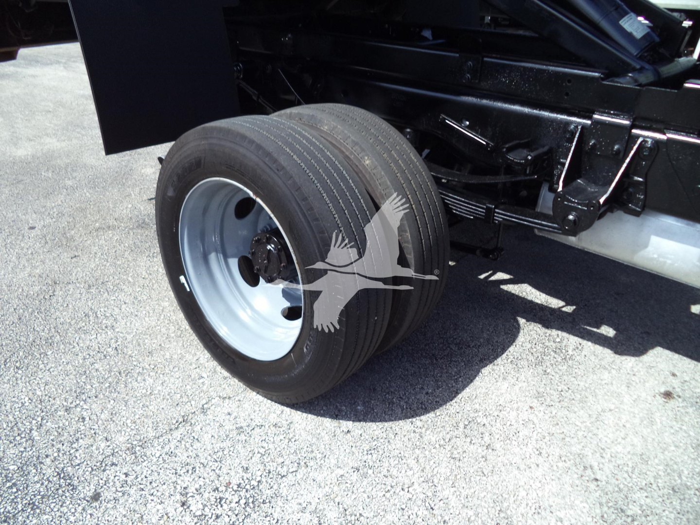 Ford F-450 dump truck rear dual rear wheel showing wheel and undercarriage components.