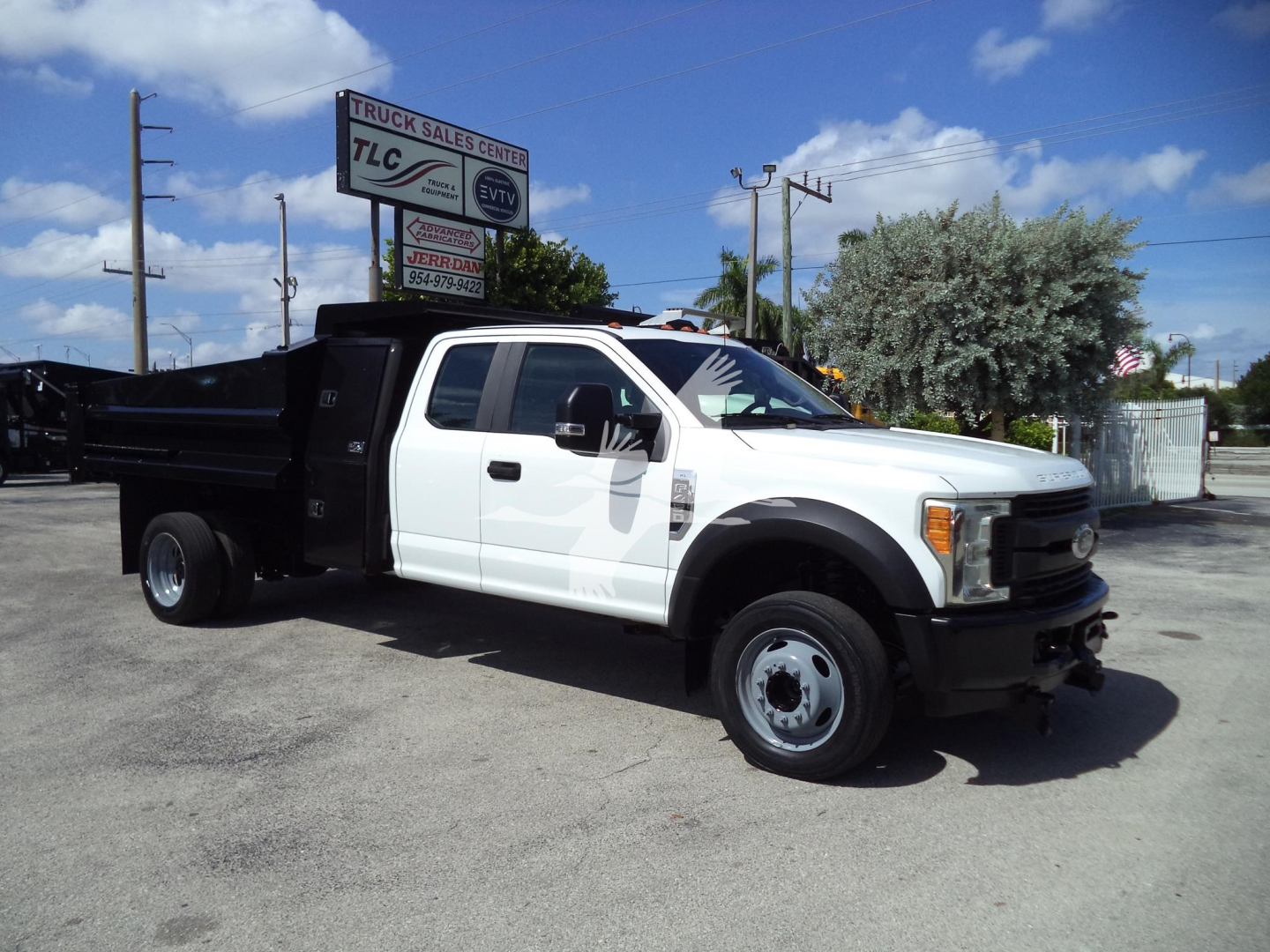 Ford F-450 dump truck white cab black dump bed, side view showing long wheelbase and dual rear wheels.