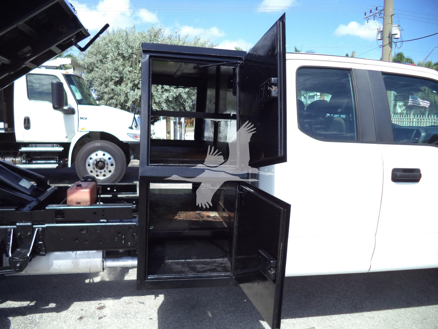 2017 Ford F450 XL dump truck with open storage compartments and a white cab. Side view shows rear storage compartments and truck bed area.