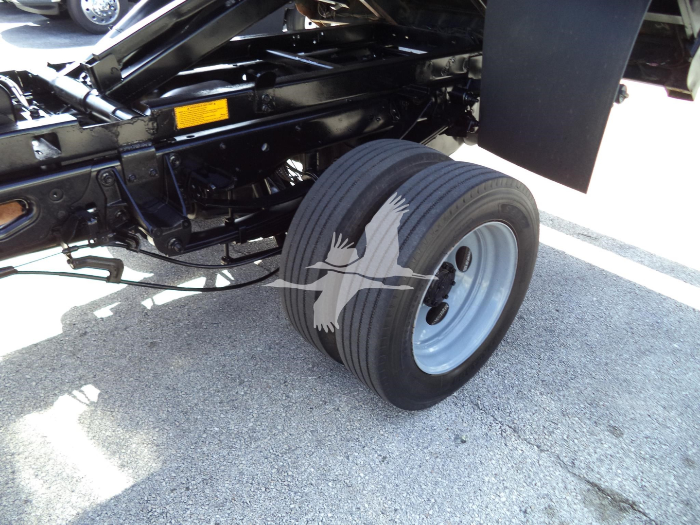 Ford truck chassis and dual rear wheel assembly showing wheel, suspension, and frame members.