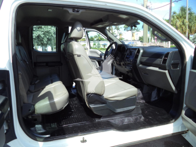 Interior of a white 2017 Ford F-450 XL pickup/dump truck shown from the driver's side with front seats and steering wheel visible.