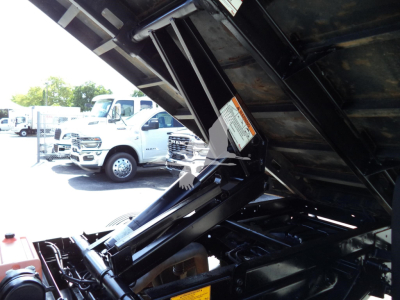 Ford F-450 truck dump bed in elevated position showing hydraulic lift and engine bay area.
