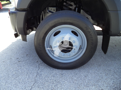 Ford F-450 front wheel and tire showing NEXEN tire, steel wheel, part of fender and suspension.