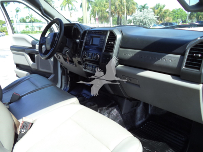 Ford F-450 interior dash and steering wheel view showing dashboard controls and beige seats.