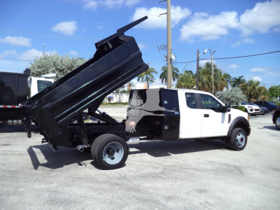 Truck dump bed raised on a 2017 Ford F450 XL with white cab and black dump bed, side view showing hydraulic lift.