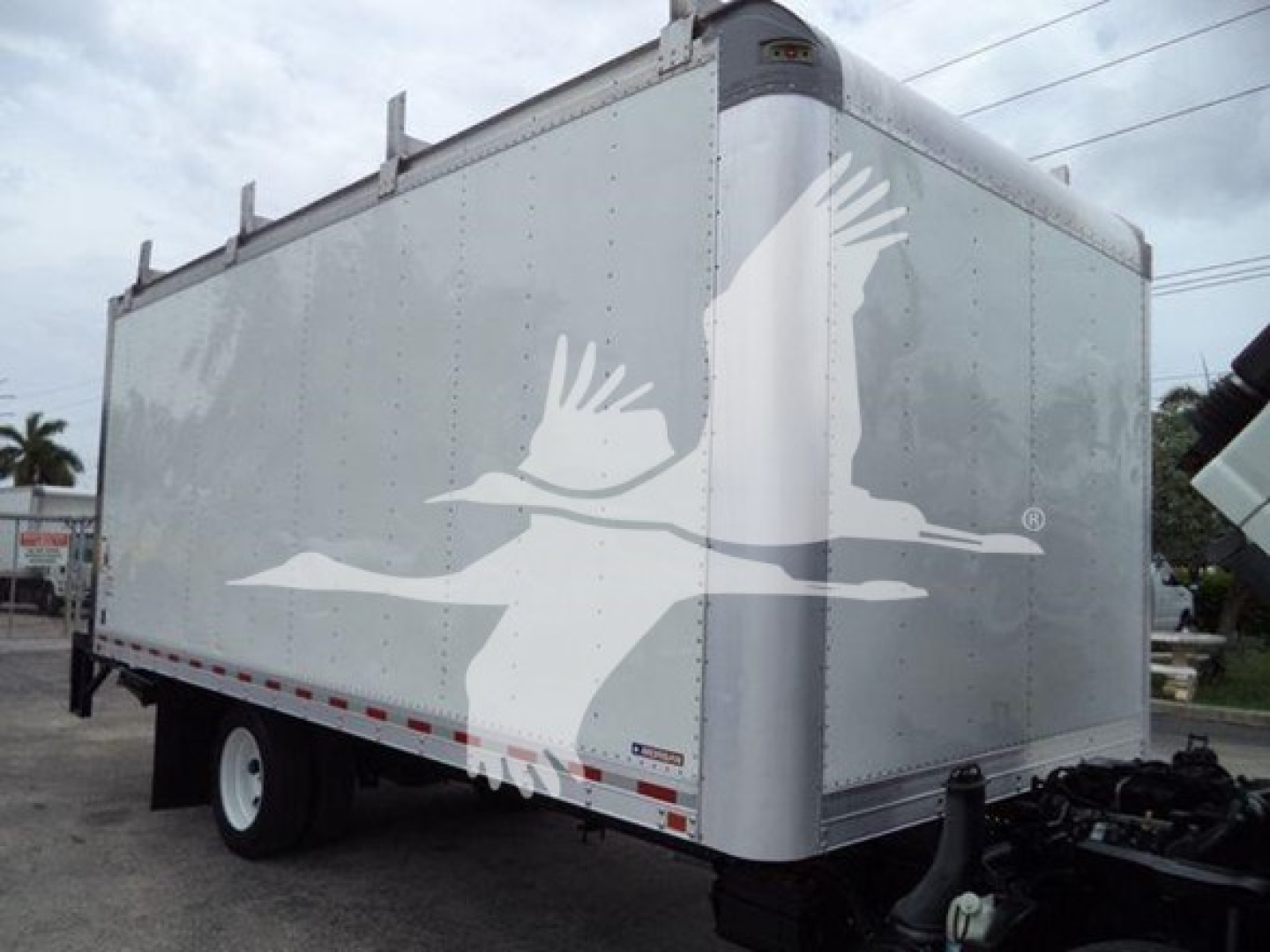 Isuzu NPR HD box truck cargo area with aluminum panels and a curved front corner, showing no visible text or logos on the side.