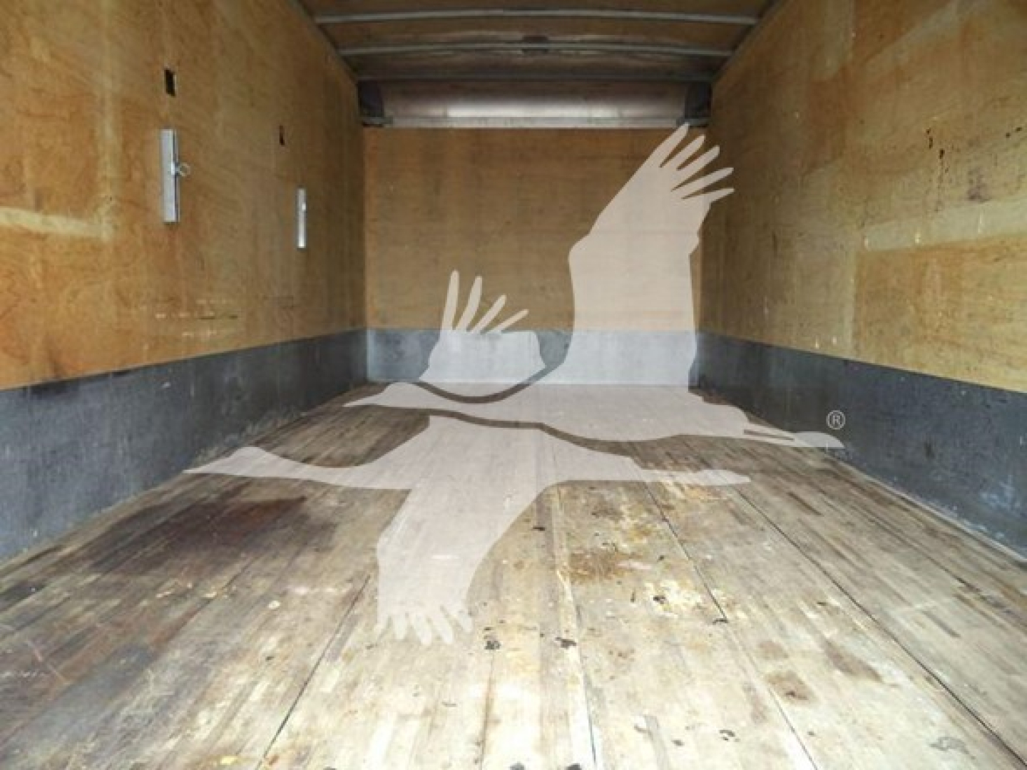 Truck cargo area showing wooden floor and walls, no visible text.