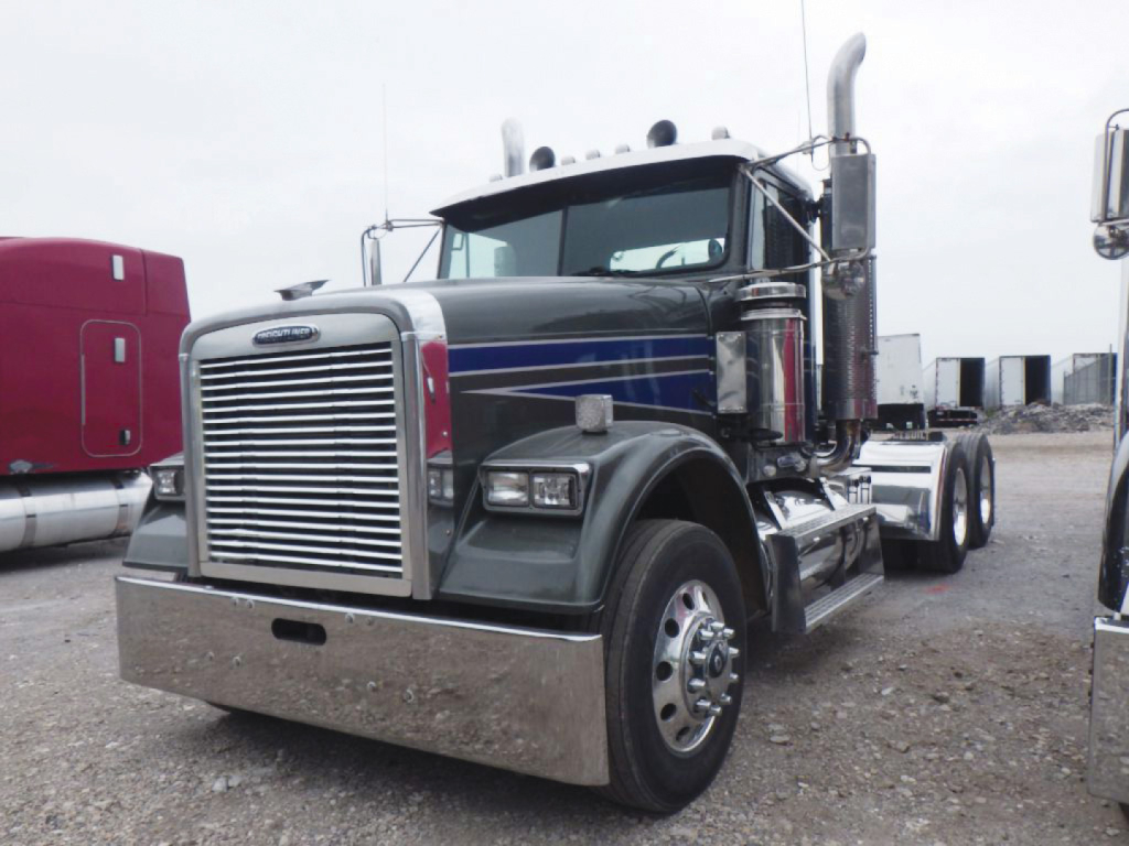 Freightliner FLD12064T Classic conventional daycab truck front view with chrome bumper and vertical exhaust stacks.