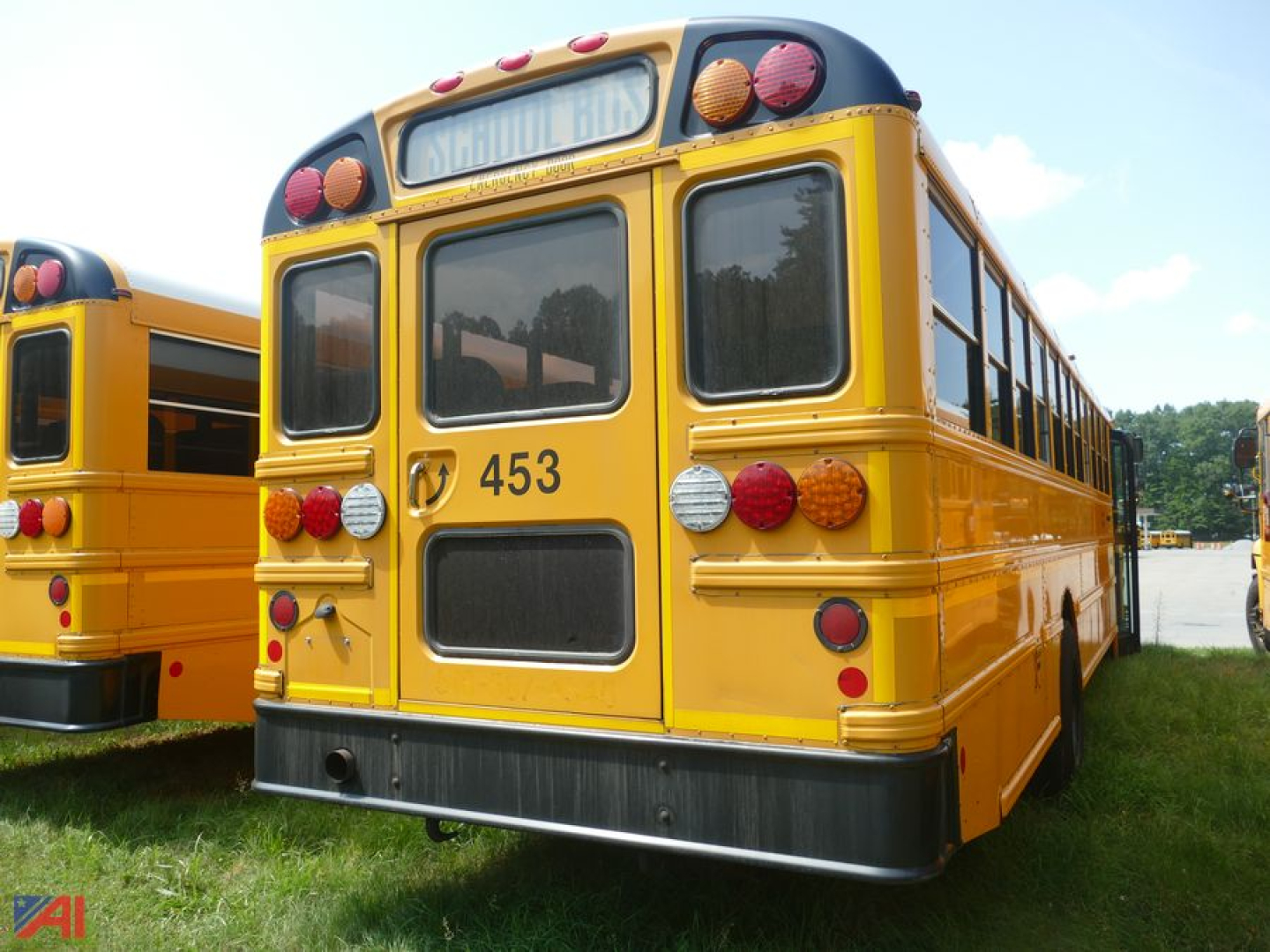 Rear view of a yellow 2019 International CE 3000 school bus showing taillights, rear bumper, and number 453, with another bus on the left.