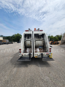 Rear view of a 2021 Freightliner M2 106 garbage truck showing two rear compactor units and taillights.