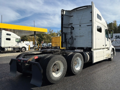 Volvo VNL 760 truck chassis with sleeper cab, rear view showing dual rear axles and fifth wheel, white exterior.