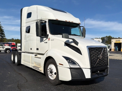 Truck cab front-left view showing Volvo VNL 760 emblem and grill; side shows 'D13' badge and black accents; white sleeper cab with aerodynamic mirrors.