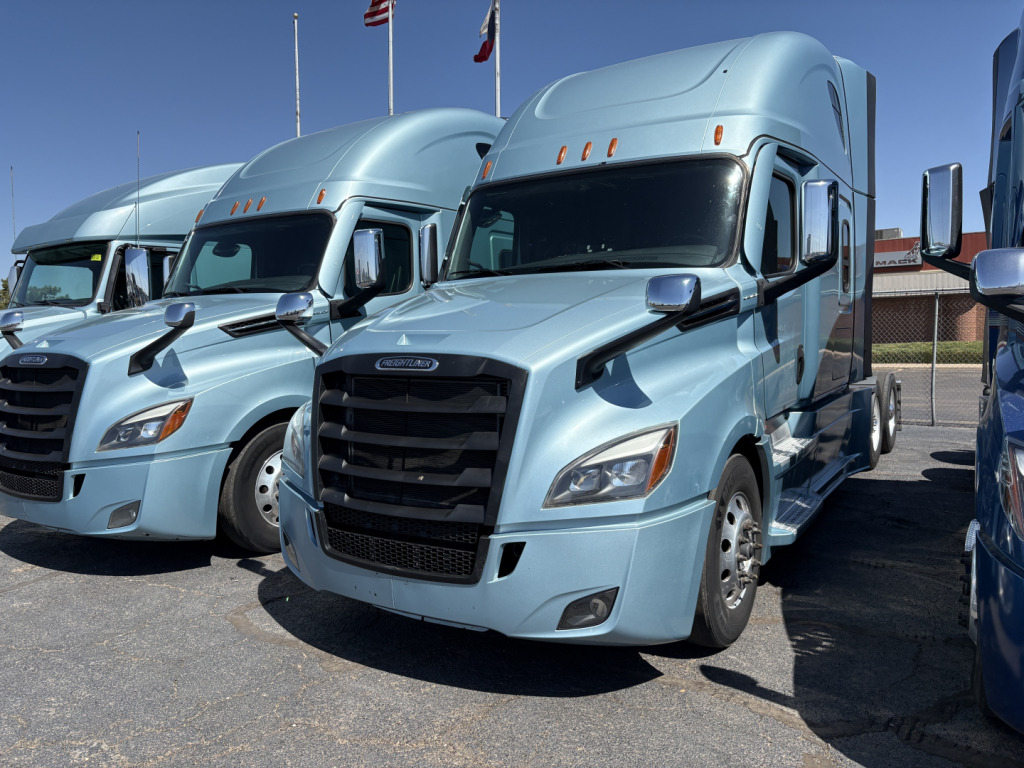  Freightliner Cascadia 126 sleeper cab truck in light blue with black grille, front view, daytime outdoor lot. 