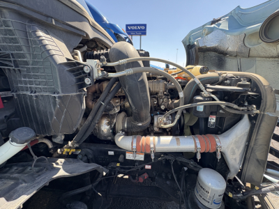 Truck engine bay with visible hoses, radiator, and intercooler piping in a Freightliner Cascadia 126.