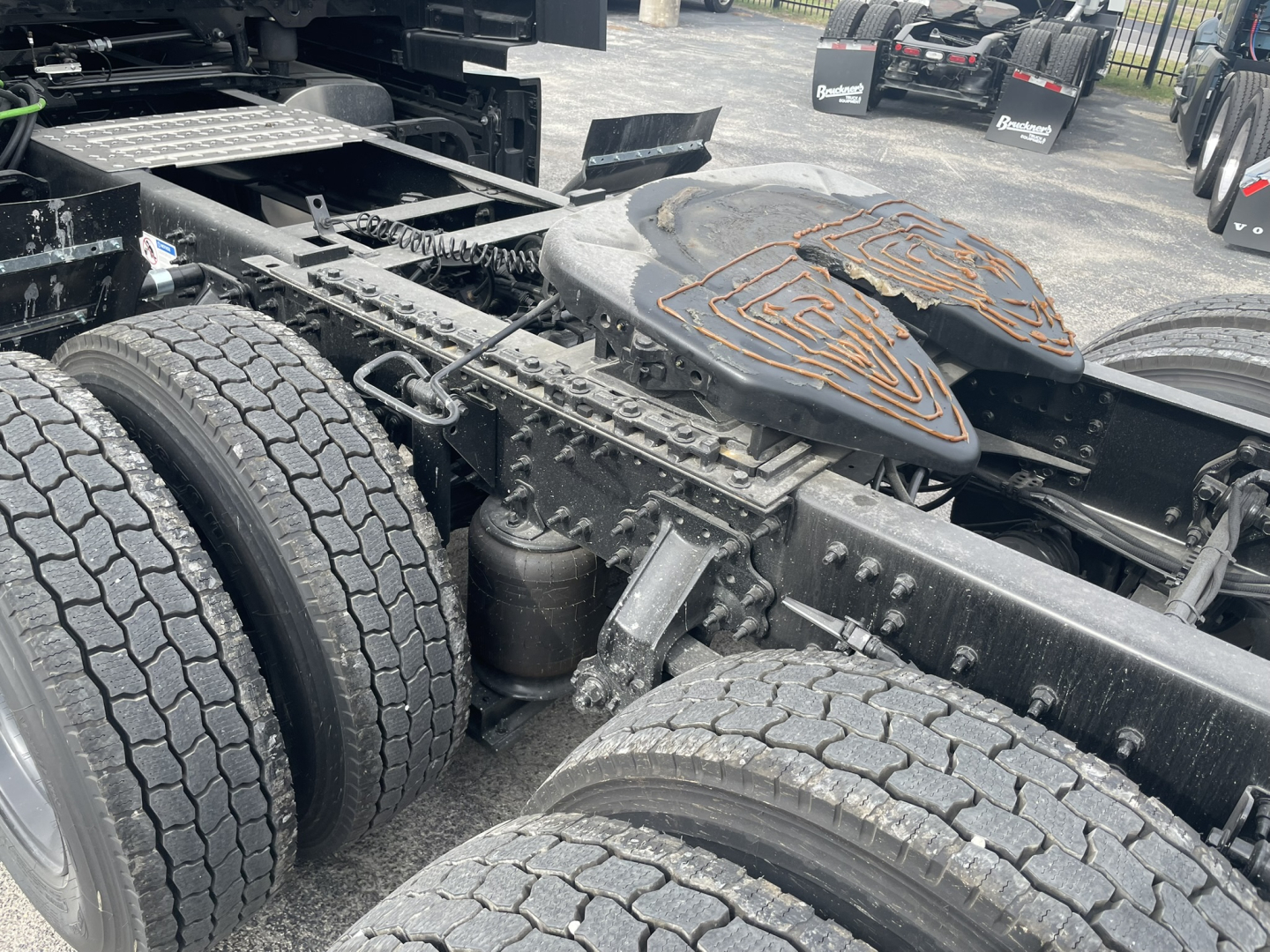 Mack PR64T76H truck chassis showing dual rear axles and fifth-wheel area with fuel/air tanks and suspension components.