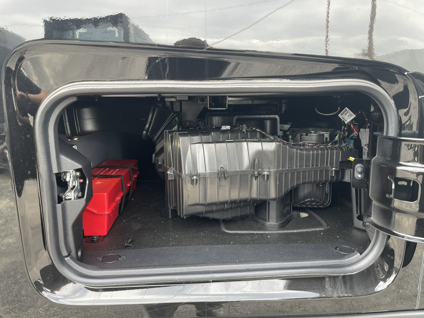 Mack PR64T76H sleeper truck engine bay showing air intake, battery pack, and compressor housing in storage compartment