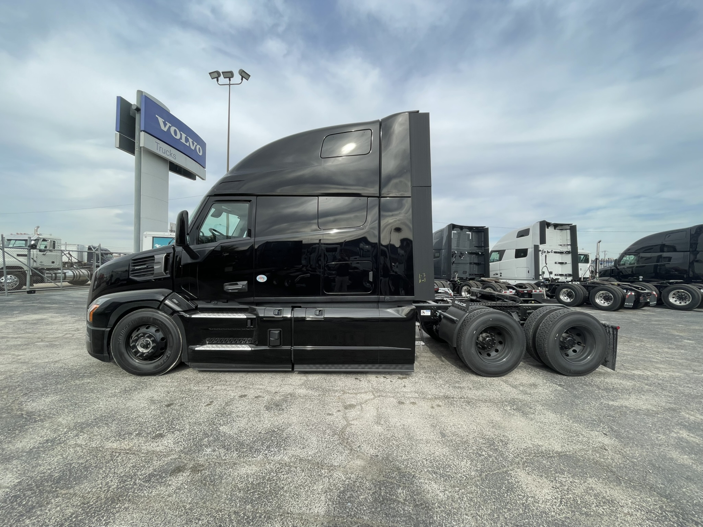 Mack PR64T76H straight truck tractor in black, side view showing sleeper cab and rear wheel axles.