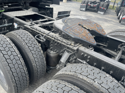 Mack PR64T76H truck chassis showing dual rear axles and fifth-wheel area with fuel/air tanks and suspension components.