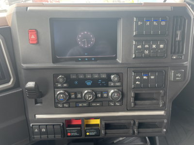 Mack PR64T76H dash cluster showing center touchscreen, climate controls, and switch panels; dashboard layout with multiple switches and storage bins.