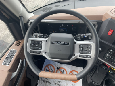 Mack PR64T76H steering wheel and dashboard showing control buttons and digital display.