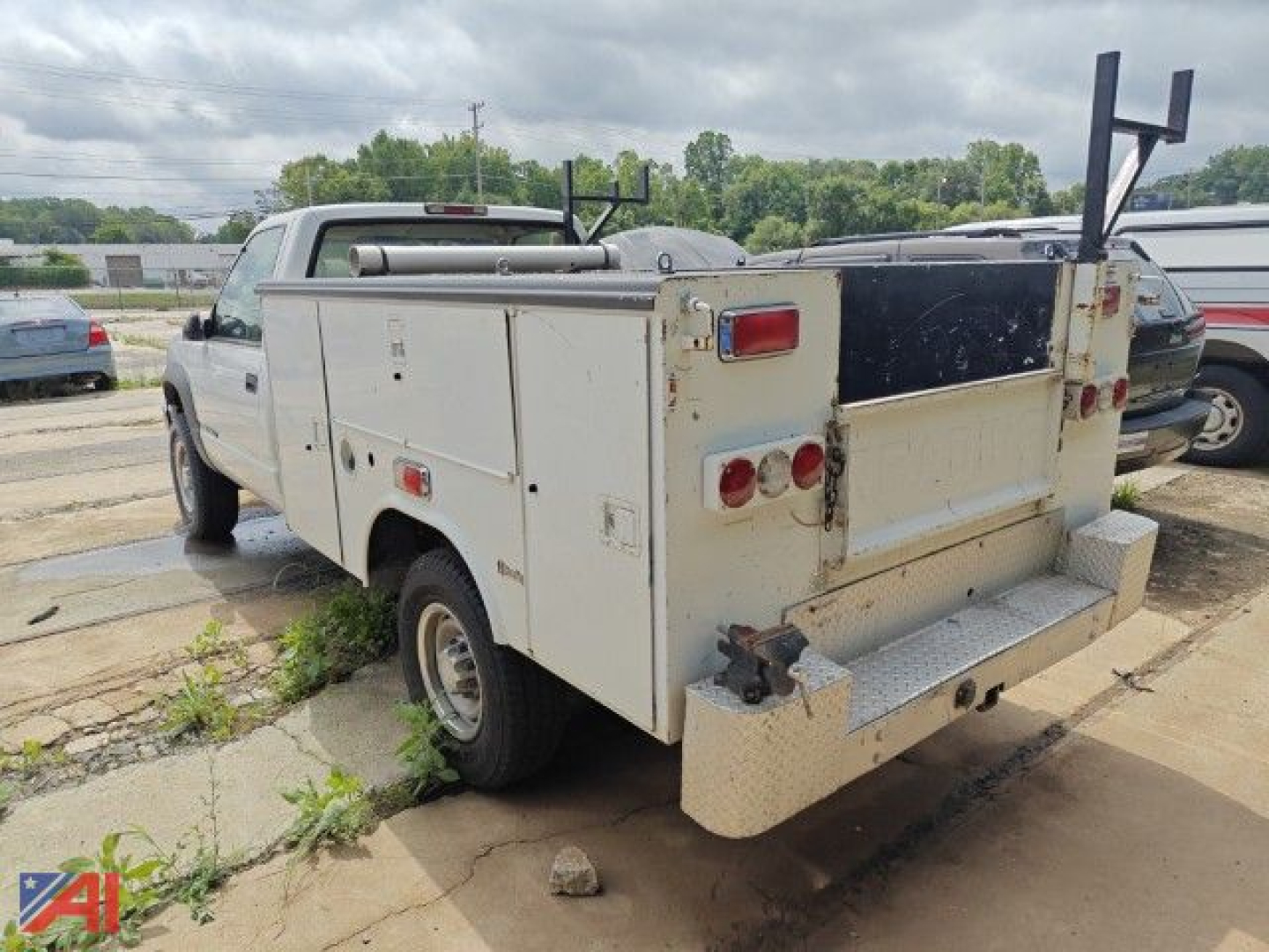 Service/utility truck body with compartments and rear equipment on a white 1995 Chevrolet C/K 3500 series utility truck viewed from rear-left, weathered panels visible.