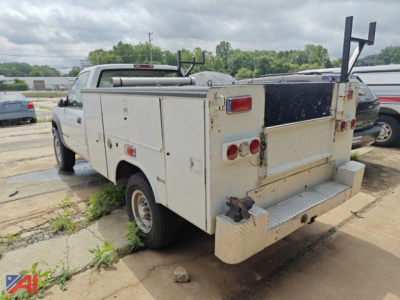 Service/utility truck body with compartments and rear equipment on a white 1995 Chevrolet C/K 3500 series utility truck viewed from rear-left, weathered panels visible.