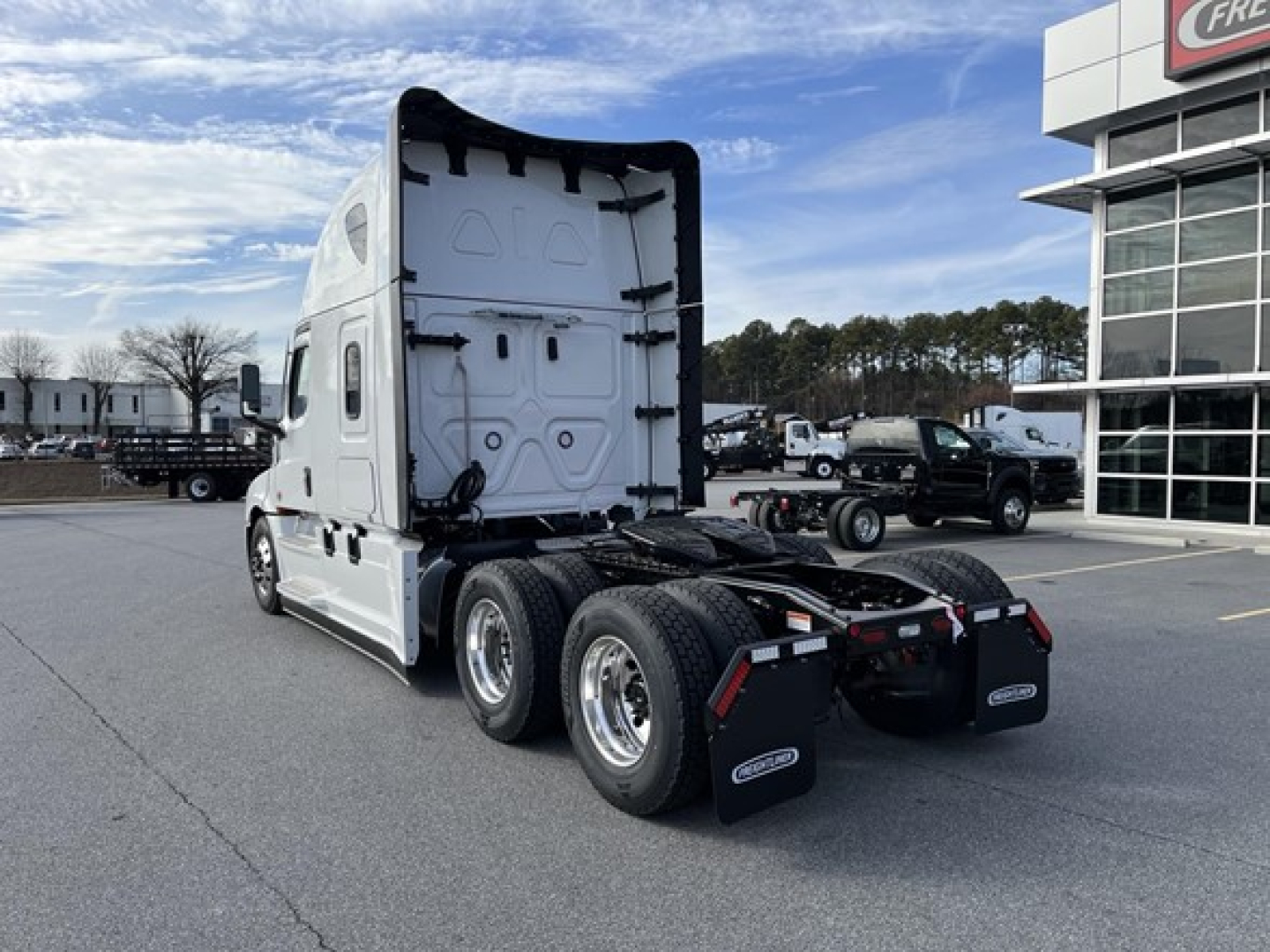 Freightliner Cascadia 126 tractor-trailer rear view showing back of cab and dual rear axles with mud flaps.