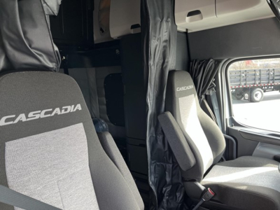 Freightliner Cascadia 126 truck interior showing driver and passenger seats with Cascadia branding.