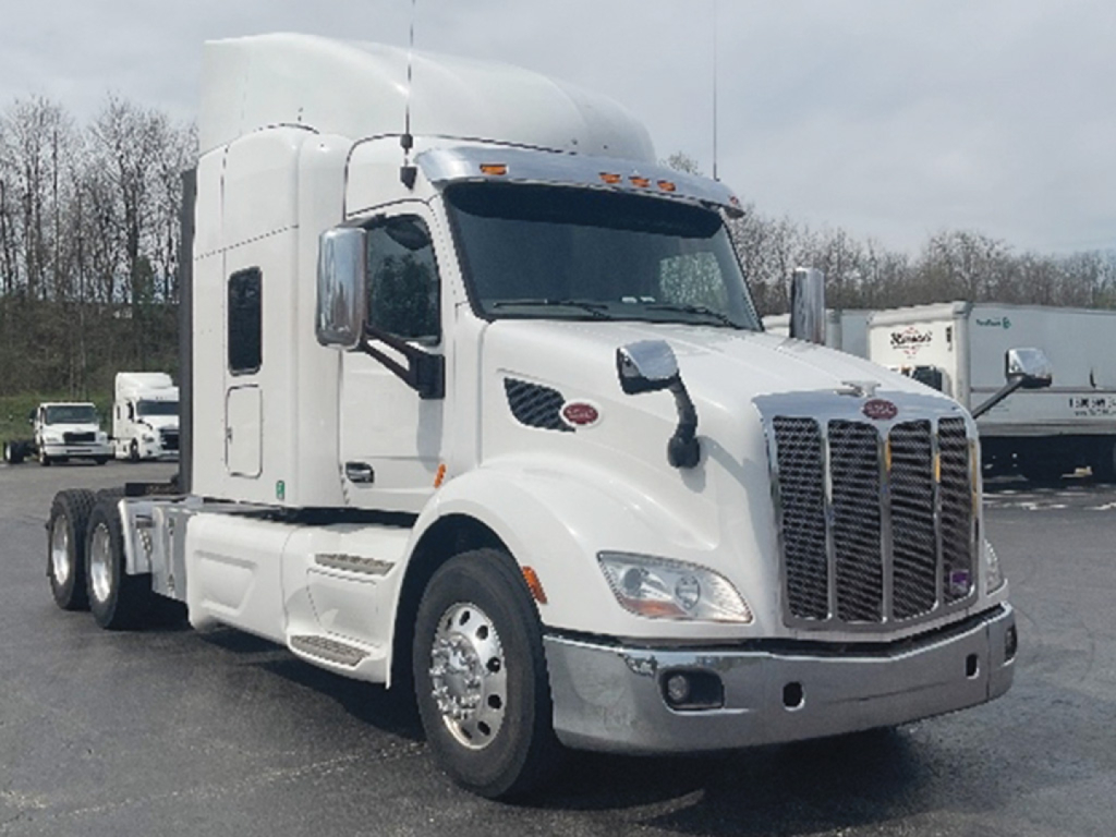 Peterbilt 579 UltraCab tractor in white, front three-quarter view showing grille, headlights, and side mirrors.