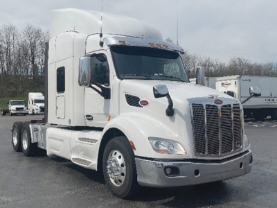 Peterbilt 579 UltraCab tractor in white, front three-quarter view showing grille, headlights, and side mirrors.