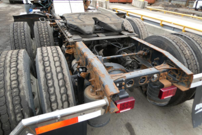 Rear view of a used 2014 International PROSTAR+ 122 semi truck chassis showing dual rear axles and frame with fifth wheel, mud flaps, and taillights.