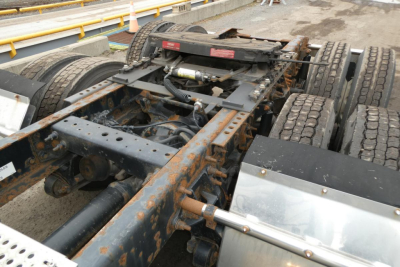 Truck chassis and fifth-wheel area of a 2014 International PROSTAR+ daycab showing frame rails, hydraulic lines, and dual rear axle components.