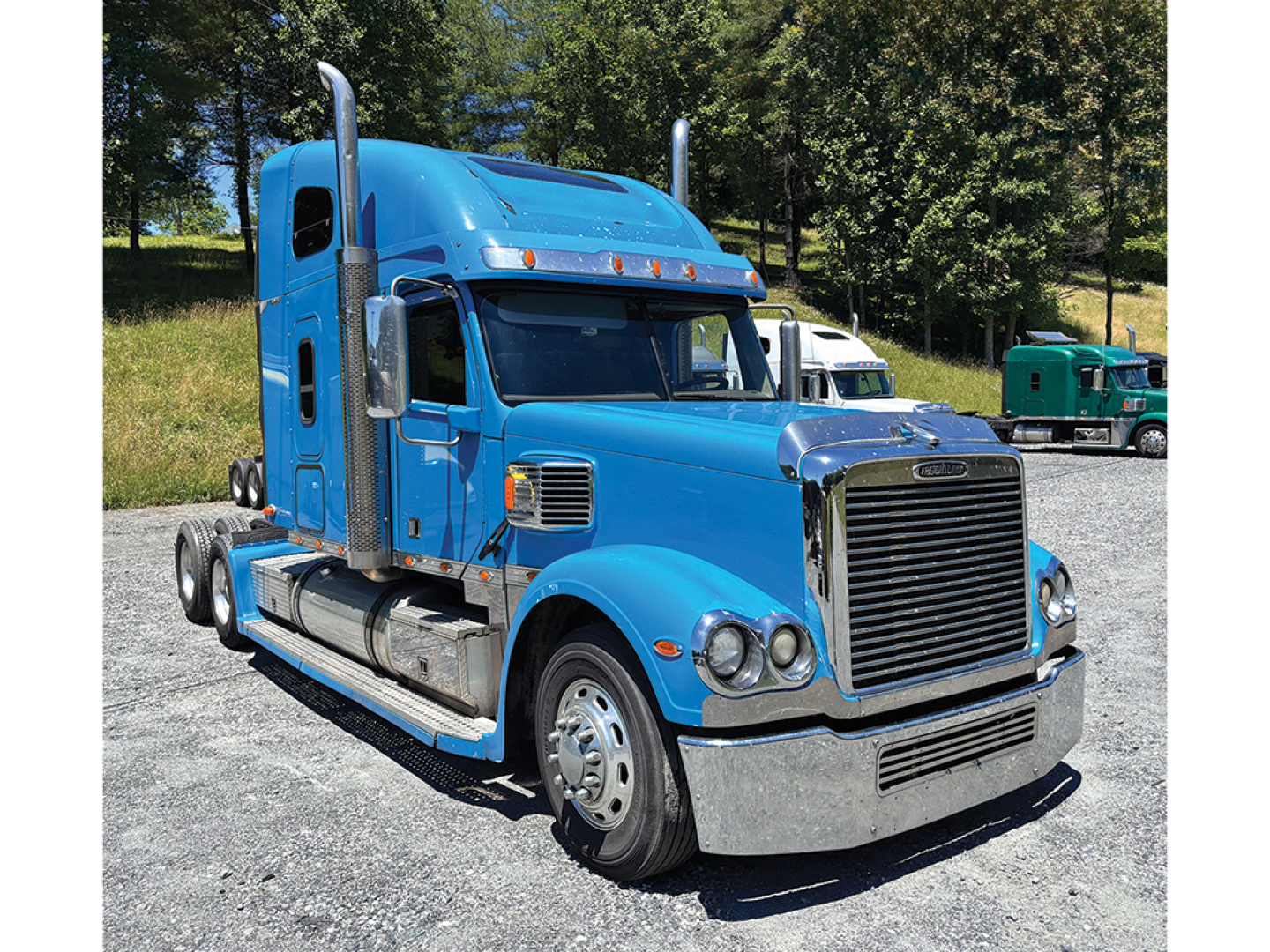 Blue Freightliner Coronado DSL truck in profile view showing cab with tall exhaust stacks, chrome bumper, and dual rear axles.