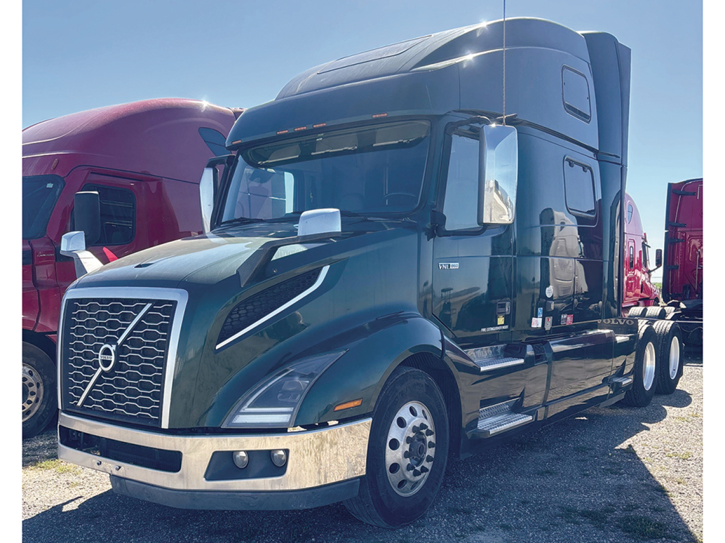 Volvo VNL 860 conventional sleeper truck in a used-truck lot, black exterior, chrome front bumper, Volvo emblem on grille, daytime running lights, aerodynamic mirrors, large sleeper cab.