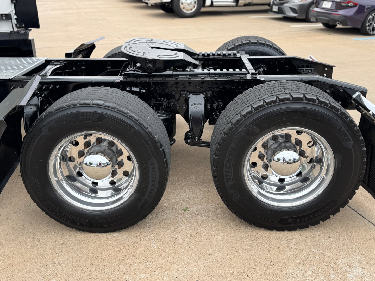 Truck chassis with dual rear axles and chrome wheels showing suspension springs and deck frame.