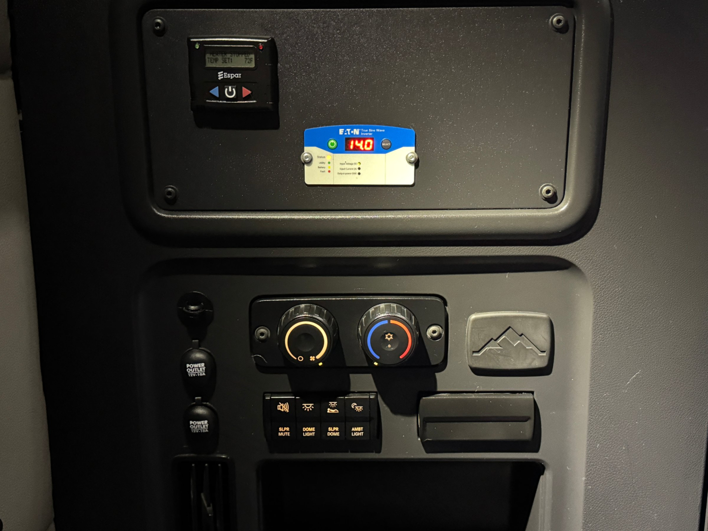 Dashboard panel of Freightliner PT126064ST showing control switches, two round dials, blue and red AC/heat controls, and a small blue badge with numbers.