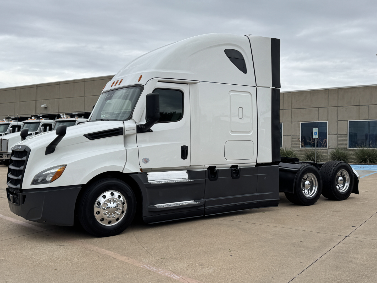 Freightliner PT126064ST truck tractor side view showing sleeper cab and three rear axles, with no visible text legibly displayed on the vehicle.
